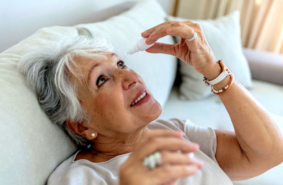 Patient instilling glaucoma eye drops at night